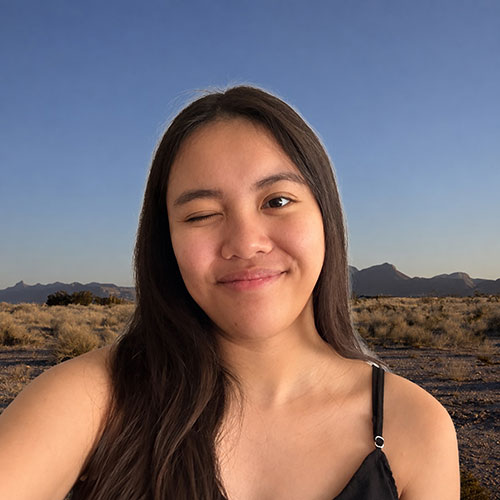 smiling and winking girl with long black hair and black top